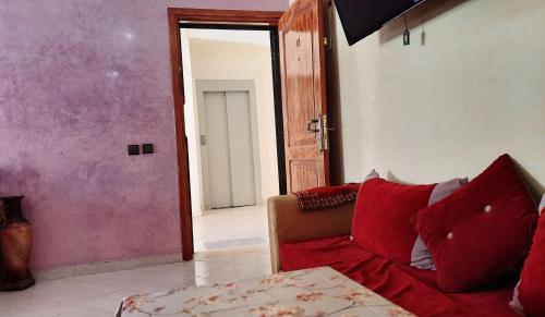 a living room with a couch and an open door at Janna appartement in Dcheira El Jihadia