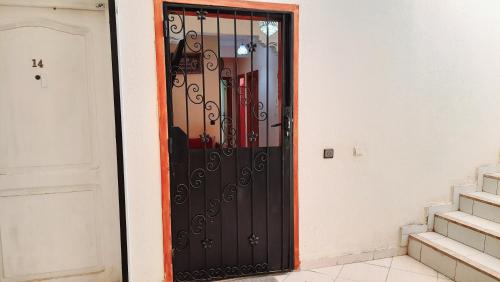 a black door in a room with a staircase at Janna appartement in Dcheira El Jihadia