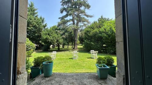 an open door to a yard with chairs and trees at ZONE BLEUE in Hyds