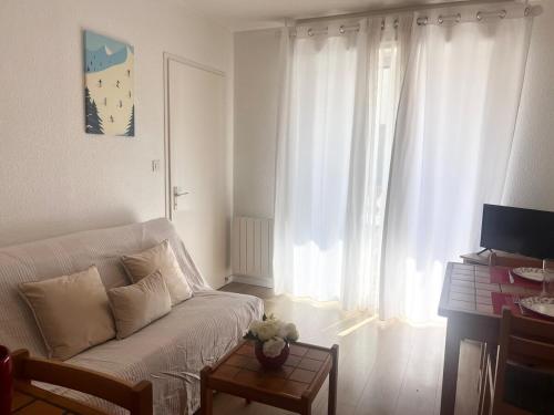 La Celle-sous-GouzonにあるCentre Ax - 4 people - ground floor - Parkingの白いソファと窓のあるリビングルーム