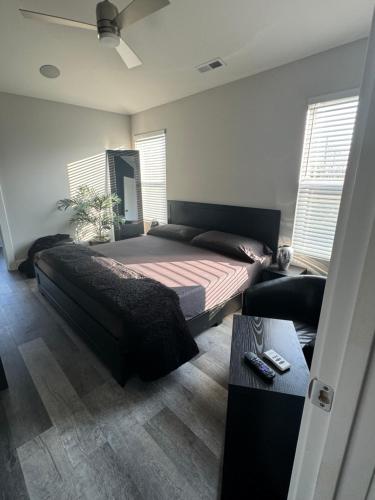 Un dormitorio con una cama y una mesa y ventanas. en Indy Pool Home, en Indianápolis