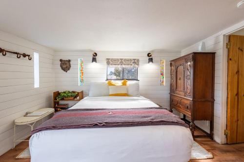 a bedroom with a large white bed and a window at Ashley's Treehouse At El Mistico Ranch in Nogal