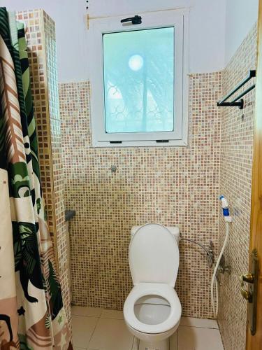 a bathroom with a toilet and a window at The heart of downtown in Nouakchott