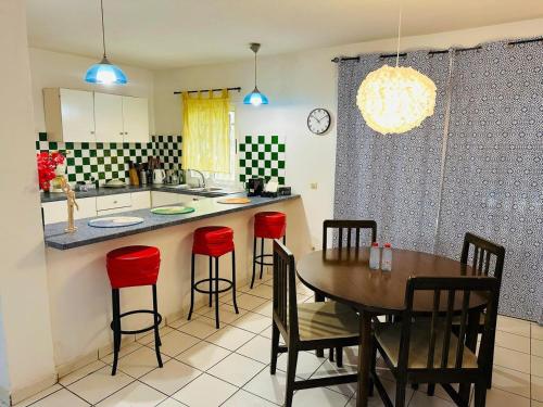 a kitchen with a table and some red chairs at The heart of downtown in Nouakchott