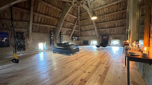 a living room with a couch and a wooden floor at ZONE BLEUE in Hyds