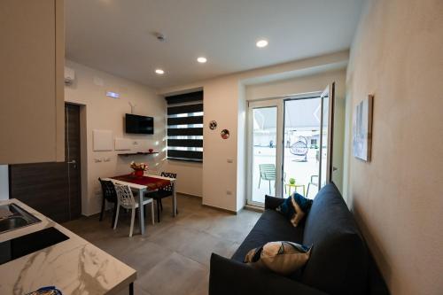 a living room with a blue couch and a table at Dimora Domitia - Apartments in Mondragone