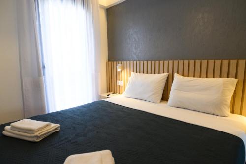a bedroom with a bed with two towels on it at Tower Luxury Flats in Alexandroupoli