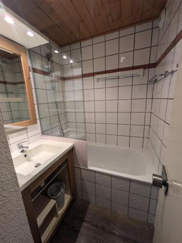 une salle de bain avec une baignoire blanche et un lavabo dans l'établissement Résidence Les Chalets des Arolles - maeva Home - Studio 4 Personnes - Confort MAE-0014, à La Plagne Tarentaise