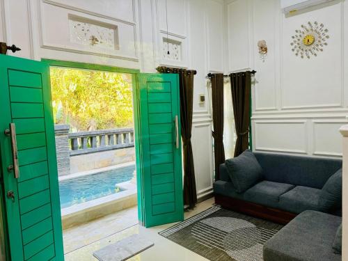 a living room with a green door and a couch at Cliff House Bali With Private Pool in Sukasada