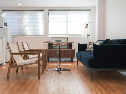 a living room with a couch and a table and chairs at Ludens House横浜山下公園 in Yokohama