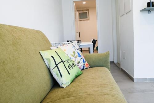 a couch with a pillow with the word faith on it at Dimora Domitia - Apartments in Mondragone