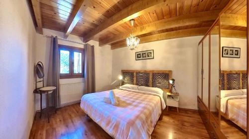 a bedroom with a bed and a wooden ceiling at Casa Pelaire Panticosa -tucasaenlospirineos in Panticosa
