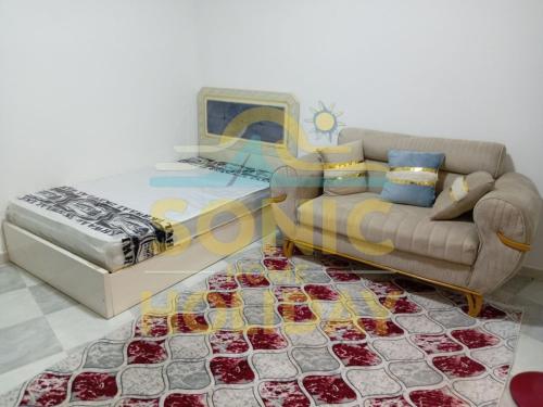 una sala de estar con un sofá y una cama en Sonic-Holidayhomes, en Alejandría