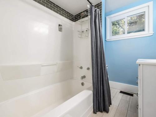 a bathroom with a white tub and a window at Columbus St Haus German Villagepetsok in Columbus