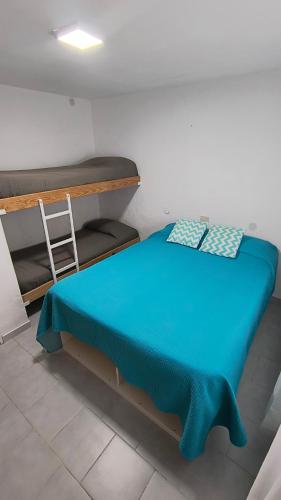 a room with a bed with a blue blanket on it at Casa 4 VLG in Las Grutas
