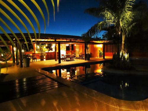 a house with a swimming pool at night at Apartamentos Breezes com verde, sossego e preço justo - ideal para famílias e amigos em Imbassaí in Imbassai