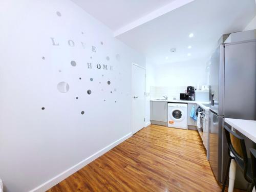 a kitchen with white walls and wooden floors at Ultra central, Near station 2BR 2BATH 6Sleep in Harrow