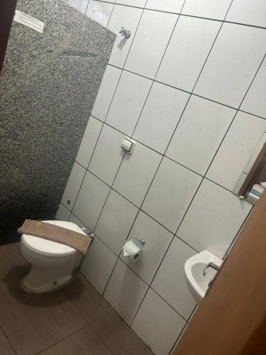 a bathroom with a toilet and a sink at Hotel Portela II - Av Principal e a 500m do Thermas dos Laranjais in Olímpia