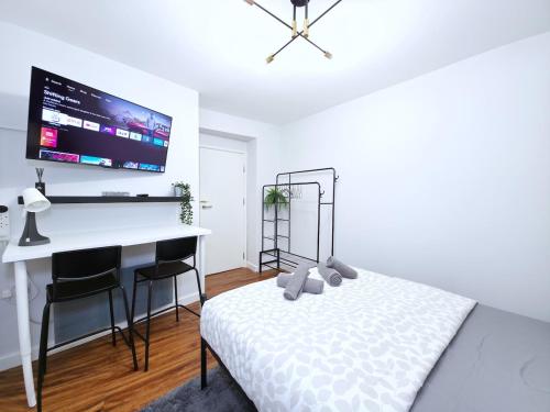 a bedroom with a bed and a desk and a tv at Ultra central, Near station 2BR 2BATH 6Sleep in Harrow