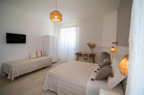 a white bedroom with two beds and a couch at Il Casale nel Parco in Rosa Marina