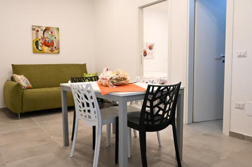 a dining room table with two chairs and a couch at Dimora Domitia - Apartments in Mondragone