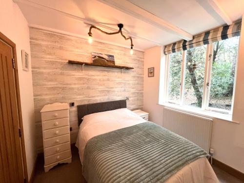 a bedroom with a bed and a wooden wall at Cromer Getaway luxury apartment in Cromer