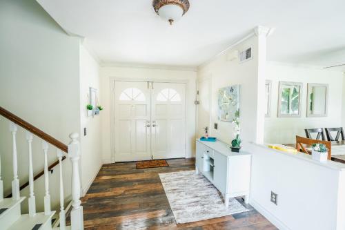 Un pasillo con paredes blancas y una escalera con pisos de madera. en Swinton, en North Hills