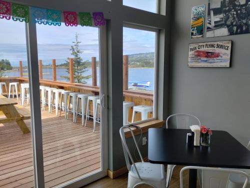 a room with a balcony with a table and chairs at Lupine Cabin - Homer Seaplane Base in Homer