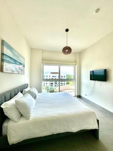 a bedroom with a large bed and a window at AmazINN Places Playa Escondida in María Chiquita