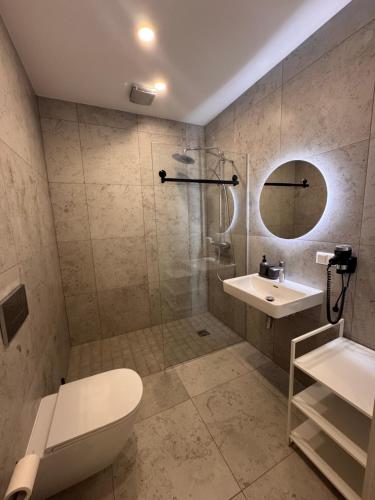 a bathroom with a shower and a toilet and a sink at Albatross apartamenti Ķesterciemā in Ķesterciems