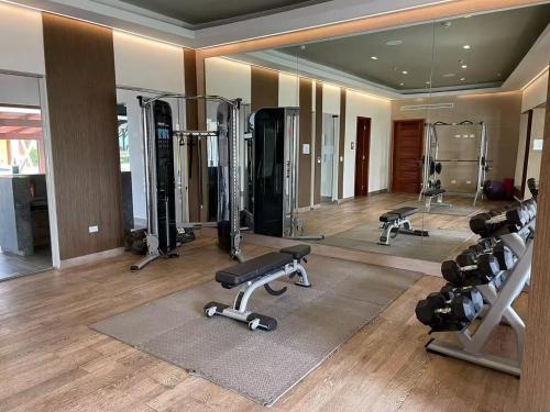 a gym with several treadmills and a mirror at AmazINN Places Playa Escondida in María Chiquita