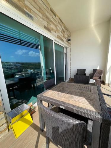 a dining room with a table and chairs and a balcony at AmazINN Places Playa Escondida in María Chiquita