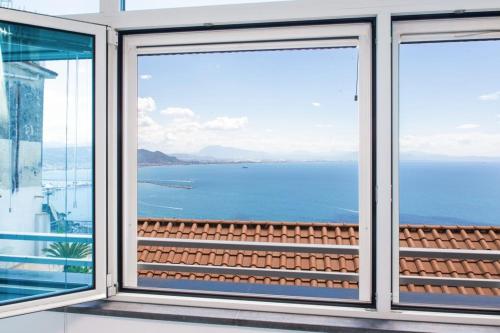 a view of the ocean from a house window at Maruzzé luxury room in Albori