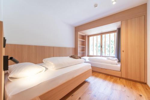 two beds in a room with a window at Linara Mountain Family Stay in Valles