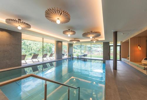 a swimming pool in a building with windows at Linara Mountain Family Stay in Valles