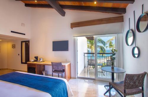 a bedroom with a bed and a table and chairs at Buenaventura Grand Hotel & Great Moments - All Inclusive in Puerto Vallarta