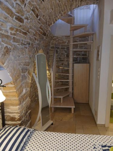 a room with a stone wall and a spiral staircase at Patrika Traditional House in Patriká