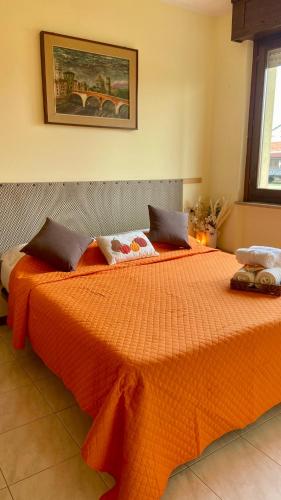 a bedroom with a bed with an orange comforter at EJ Station Corner in Verona