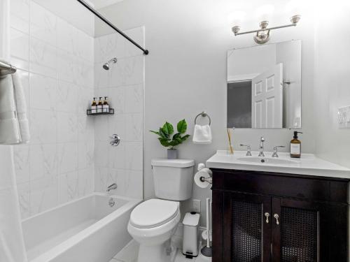 a white bathroom with a toilet and a sink at Boston 4BR Home with Parking BBQ Fire in Somerville