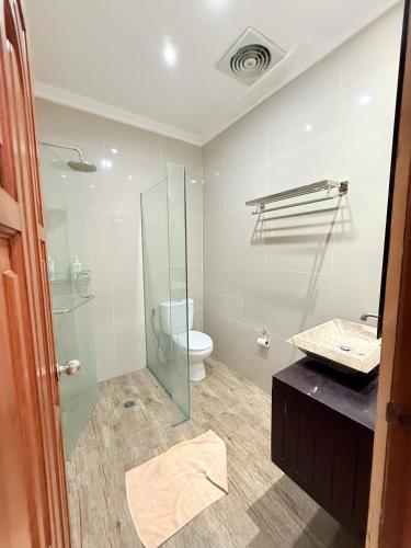 a bathroom with a toilet and a glass shower at Villa Mimi Mesari Kuta Bali in Kuta