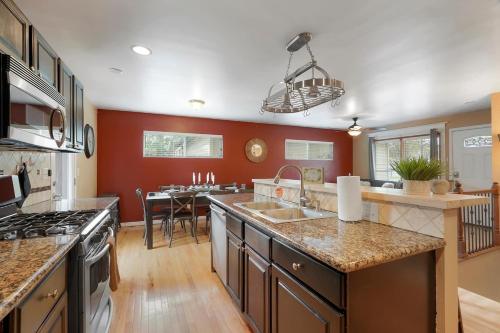 a large kitchen with red walls and a kitchen island at Arvada home w hot tub & BBQ in Arvada