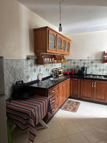a kitchen with wooden cabinets and a black counter top at Suit Home in Martil