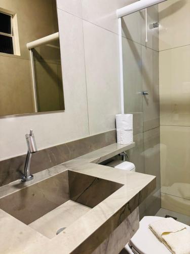 a bathroom with a sink and a mirror and a toilet at Pousada Ilha Bella in Fernando de Noronha