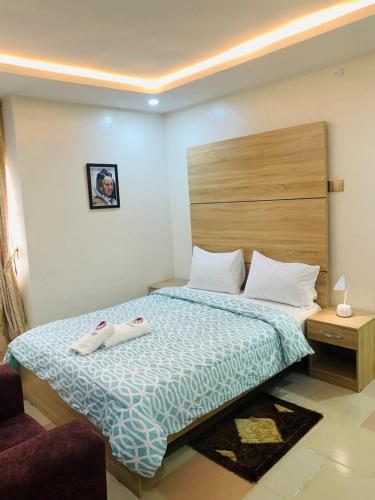 a bedroom with a bed with two towels on it at Eagle Nest Apartment and Hotel in Benin City