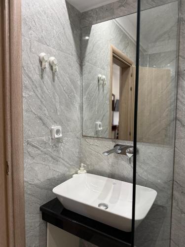 a bathroom with a white sink and a mirror at Vironas Hotel in Himare