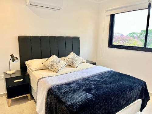 Un dormitorio con una cama con una ventana grande. en Edificio Brooklyn, en Asunción