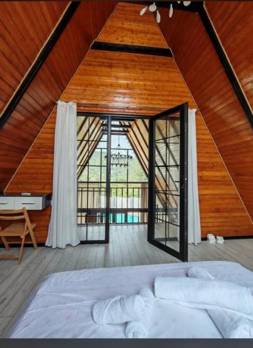 a bedroom with a bed and a large window at Huzoor Aframe Gabala in Gabala