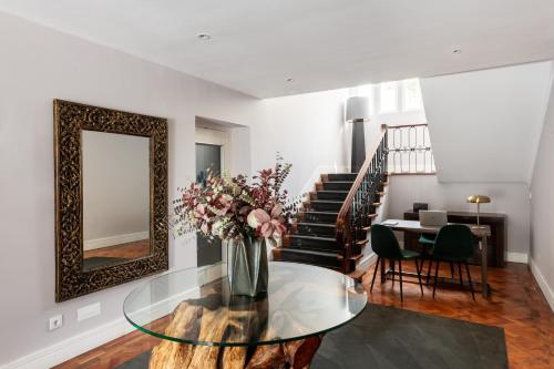 a living room with a glass table and a mirror at AvenueHillHotel in Lisbon