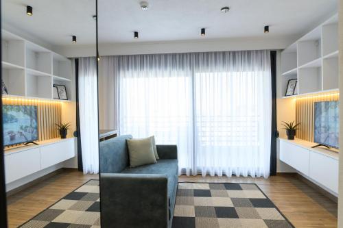 a living room with a couch and a large window at Tower Luxury Flats in Alexandroupoli