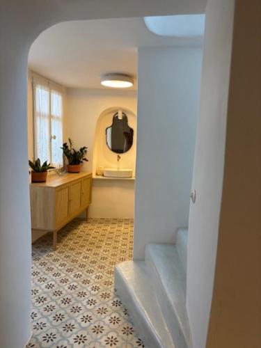 a hallway with stairs and a sink and a mirror at Mona in Poros